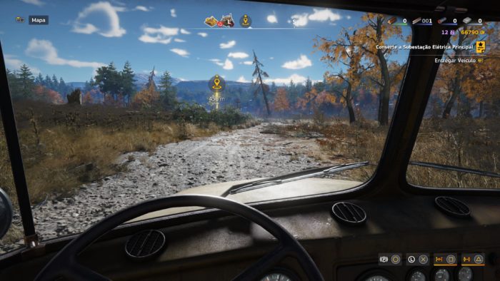 A imagem mostra a visão por dentro da cabine de um caminhão, indo em direção a uma marcação virtual no cenário no jogo RoadCraft. A estrada à frente é ruim, cheia de lama e pedras. A paisagem no fundo é bonita.